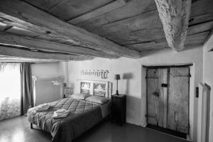 ComanoViandanti, Artisti e Sognatori的一间卧室设有一张床和木制天花板