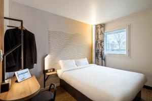 楠泰尔B&B HOTEL NANTERRE Rueil-Malmaison的一间设有大床和窗户的酒店客房