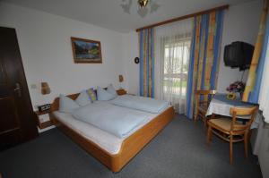 瓦尔赫湖噶斯特豪斯发格酒店的一间卧室配有一张床、一张桌子和一个窗户。