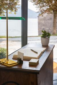坎诺比奥Villa Maria Hotel的一张带台灯的桌子和上面的书籍