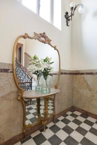 坎诺比奥Villa Maria Hotel的一张桌子,上面有镜子和花瓶