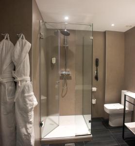 马德里马德里中央美居酒店的一间带卫生间的浴室内的玻璃淋浴间