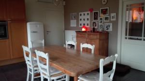 比尔曾B&B De Laak的厨房配有木桌和白色椅子