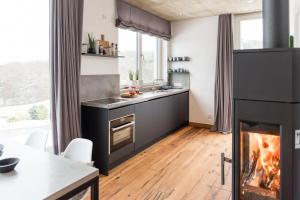 巴特明斯特艾弗尔N8Quartier Eifel的厨房设有壁炉和桌椅