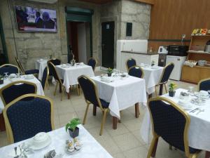波尔图波尔图黎各宾馆的一间带白色桌椅的餐厅和一间厨房