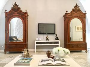卡塔尼亚Dimora del Papa的客厅配有电视和桌子,备有书籍
