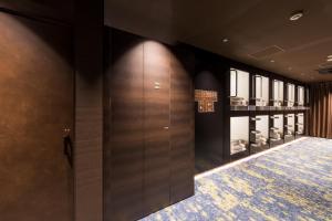 东京秋叶原格兰斯特胶囊旅馆的步入式衣柜,带木门和地毯