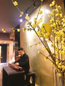 重庆漫途高空江景酒店（解放碑洪崖洞夜景店  ) 的坐在植物旁边的桌子上的男人
