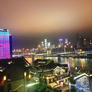 重庆漫途高空江景酒店（解放碑洪崖洞夜景店  ) 的城市天际线,夜晚有河流和建筑