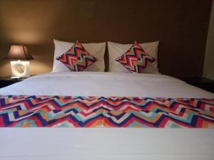 金巴兰巴厘岛乌鲁民宿的一张带五颜六色的被子和两个枕头的床