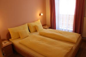 圣坎迪朵豪斯沃德合公寓的一间卧室配有一张带黄色床单的床和一扇窗户。