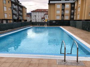 温克拉Apartamento Unquera - Cantabria的一座大型游泳池,位于部分建筑的中间