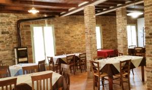 CasinaAgriturismo di Sordiglio的用餐室设有桌椅和砖墙