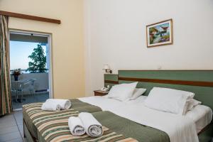 斯卡拉Porto Skala Hotel Village的酒店客房,配有两张带毛巾的床