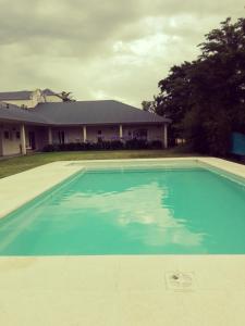 坦迪尔Hosteria Ruphay的一座大蓝色游泳池,位于房子前