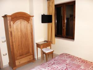 卡普阿拉可罗姆巴雅农家乐的一间卧室配有一张床和一个木制橱柜