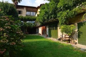 CasalzuignoIl Cortile - Casa d'Artista的一座带绿门的建筑的庭院