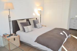 里斯本TP Aqueduto Lisbon House的卧室配有带枕头的大型白色床