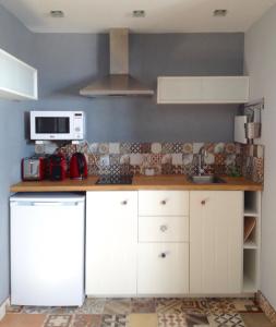 科武港Casa de Mar @ Porto Côvo的厨房配有白色橱柜和微波炉