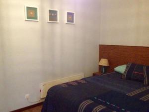 科武港Casa de Mar @ Porto Côvo的卧室配有一张床,墙上挂有图片