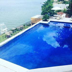 特克塞丁戈Depa Teques的毗邻大海的大型蓝色游泳池