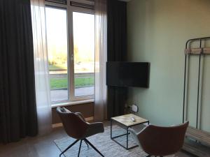 格罗宁根De Kade的酒店客房设有两把椅子、一张桌子和电视。