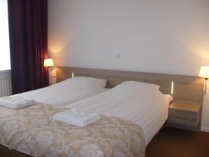 诺格诺格酒店的一间卧室配有一张床,上面有两条毛巾