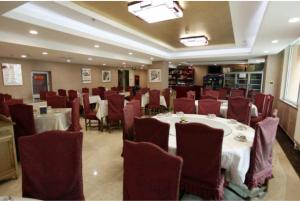 顺义格林豪泰北京市顺义区新国展快捷酒店的用餐室配有白色的桌子和红色的椅子