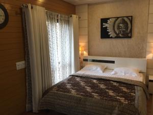 古尔冈Beautiful Apartments at Tarudhan Valley Golf Resort, Manesar的一间卧室设有一张大床和一个窗户。