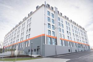 慕尼黑慕尼黑格里斯菲尔德街第一睡眠公寓式酒店的一座白色的大建筑,上面有橙色条纹