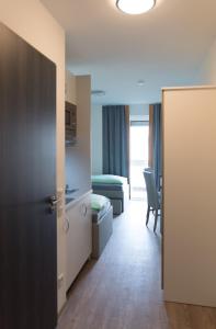 慕尼黑慕尼黑格里斯菲尔德街第一睡眠公寓式酒店的一间设有一张床的房间和一间带门的房间