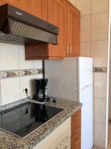 卡亚俄萨尔瓦赫El Ancla的厨房配有白色冰箱和炉灶。