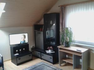 希尔兴巴赫Ferienwohnung Bäumener的一间带电视和书桌的客厅