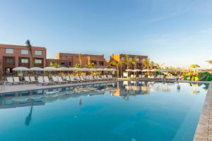 马拉喀什Be Live Experience Marrakech Palmeraie - All Inclusive的一个带椅子和遮阳伞的大型游泳池