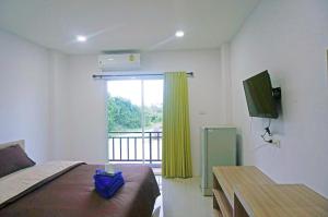 华欣AD住宿公寓的一间卧室设有一张床和一个带电视的窗户。