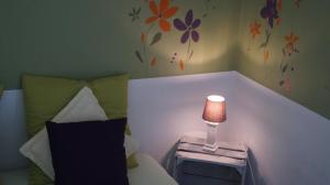 迪南Gite Saboti的一间卧室,配有一张带台灯的床头柜