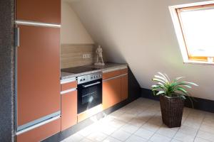 布里隆FeWo zur weißen Frau的厨房配有橙色橱柜和炉灶。
