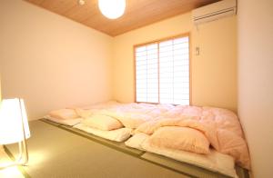 京都一棟貸切り宿 GuestHouse 嵯峨嵐山的窗户客房内的一张大床