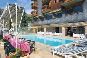 土绪尔乐斯苏丹内尔酒店的酒店设有带桌椅的游泳池