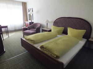 摩泽尔肯Hotel Moselkern的一张位于酒店客房的床位,配有黄色枕头