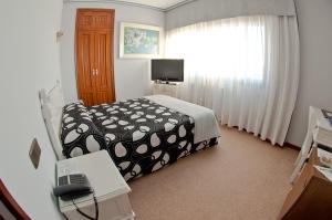 波伊奥唐佩皮酒店的一间卧室配有一张床和一张带电话的书桌