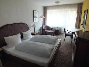 摩泽尔肯Hotel Moselkern的酒店客房配有两张床和一张书桌