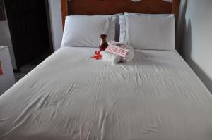 莫罗圣保罗Amendoeira Hotel da Vila的一张带瓶子和毛巾的白色床