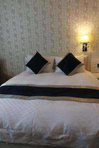 金城浯江大饭店的卧室内一张带黑色枕头的大型白色床