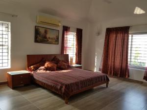 钦奈Elysium Kovalam的一间卧室配有一张带红色窗帘的大床