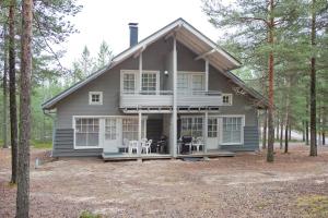 卡拉约基Holiday Club Kalajoki Cottages的树林中的房屋,设有门廊和椅子