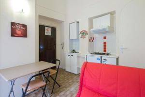 阿斯蒂Location Turistic by Heart of Asti CIR 00032的一间厨房,内设桌子和红色沙发