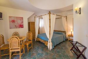 兰佩杜萨Luna di Ponente的卧室配有一张床和一张桌子及椅子