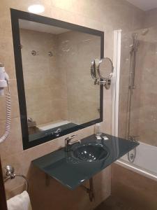韦尔瓦Hotel Familia Conde的一间带水槽和镜子的浴室