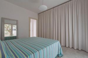 莱乌卡Villetta Federica by BarbarHouse的一间卧室配有床和带窗帘的窗户